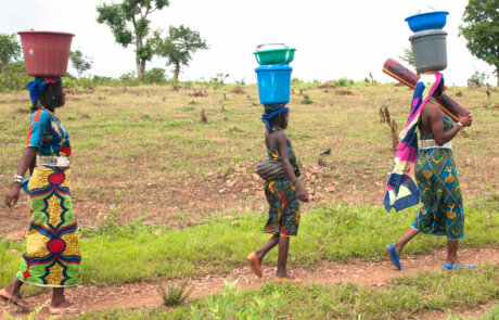 カメルーン、ポリで頭に水の容器をのせて歩くムボロロ族の女性たち